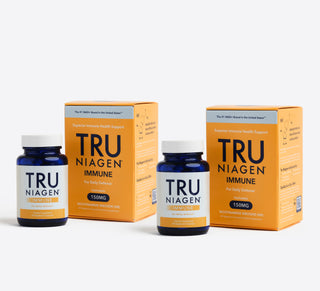 Two bottles of Tru Niagen Immune dietary supplement with 150mg of Niagen in front of the orange carton packaging they come in.
