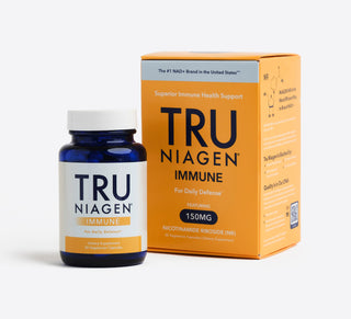 A blue bottle of Tru Niagen Immune supplements in front of the orange carton packaging the product comes in.